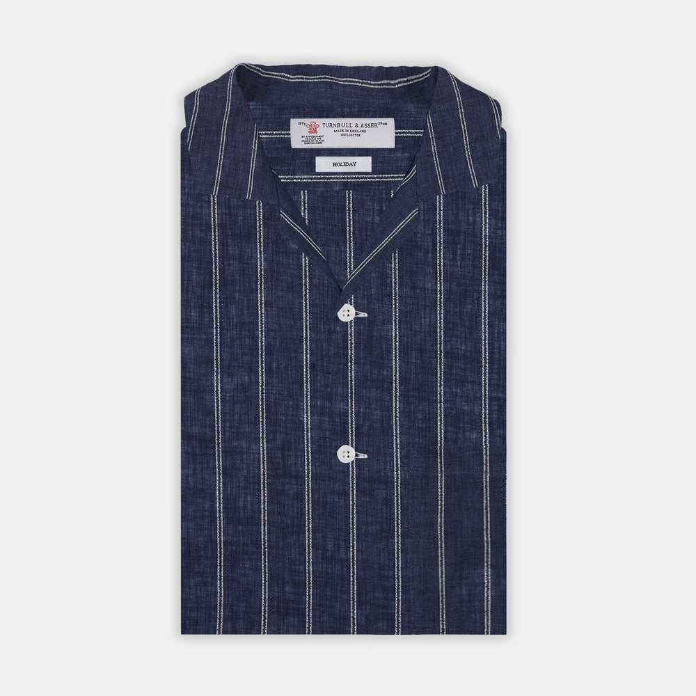 The Turnbull & Asser Holiday Fit Stripe Linen Short Sleeve Shirt features a navy background with vertical white stripes, a revere collar, and white buttons.