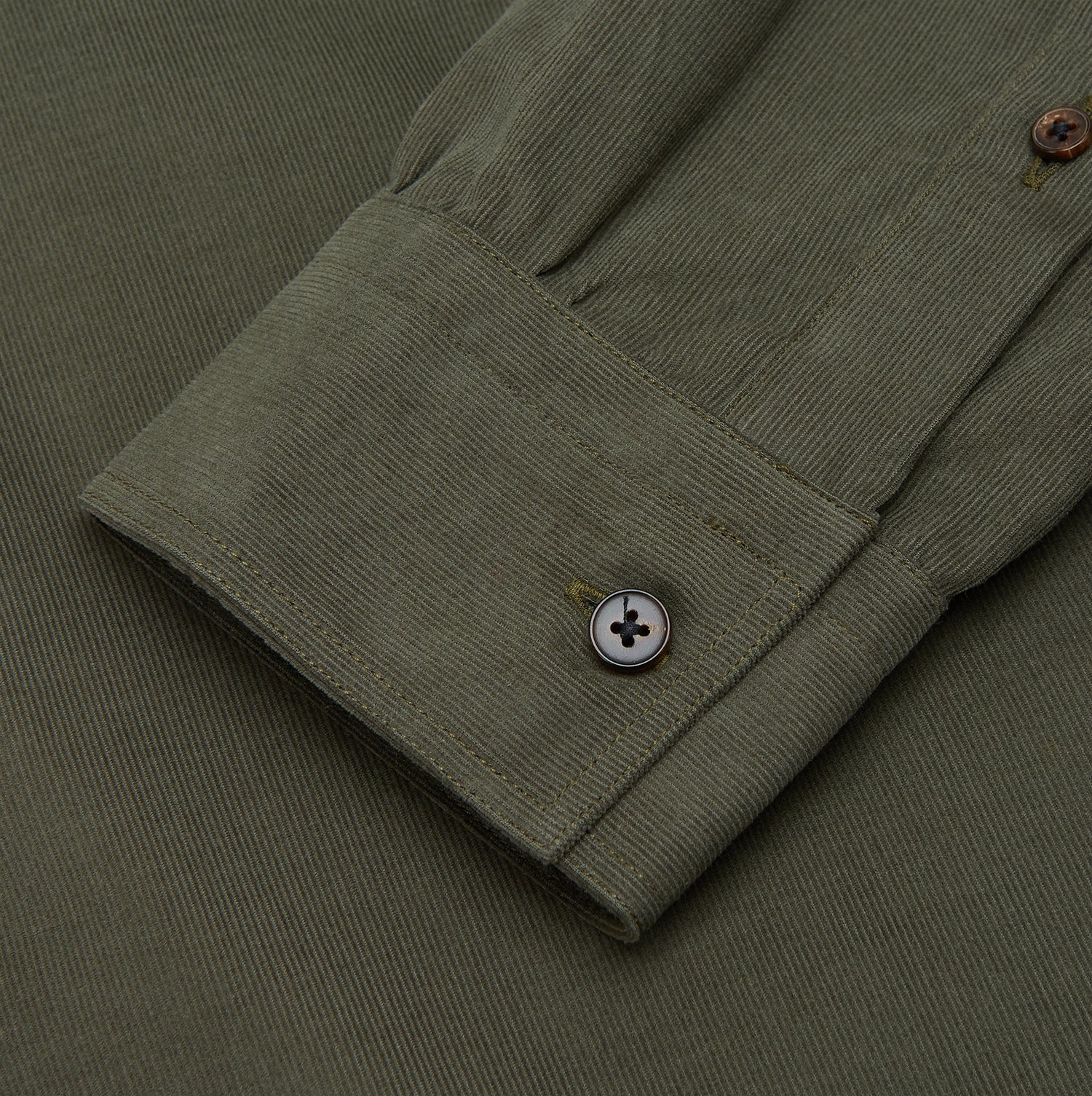 View 3 of product The Turnbull & Asser Khaki Corduroy Officer Weekend Fit Shirt features a Dorset collar, one-button cuffs, and two chest pockets with buttoned flaps, shown laid flat on a white background.