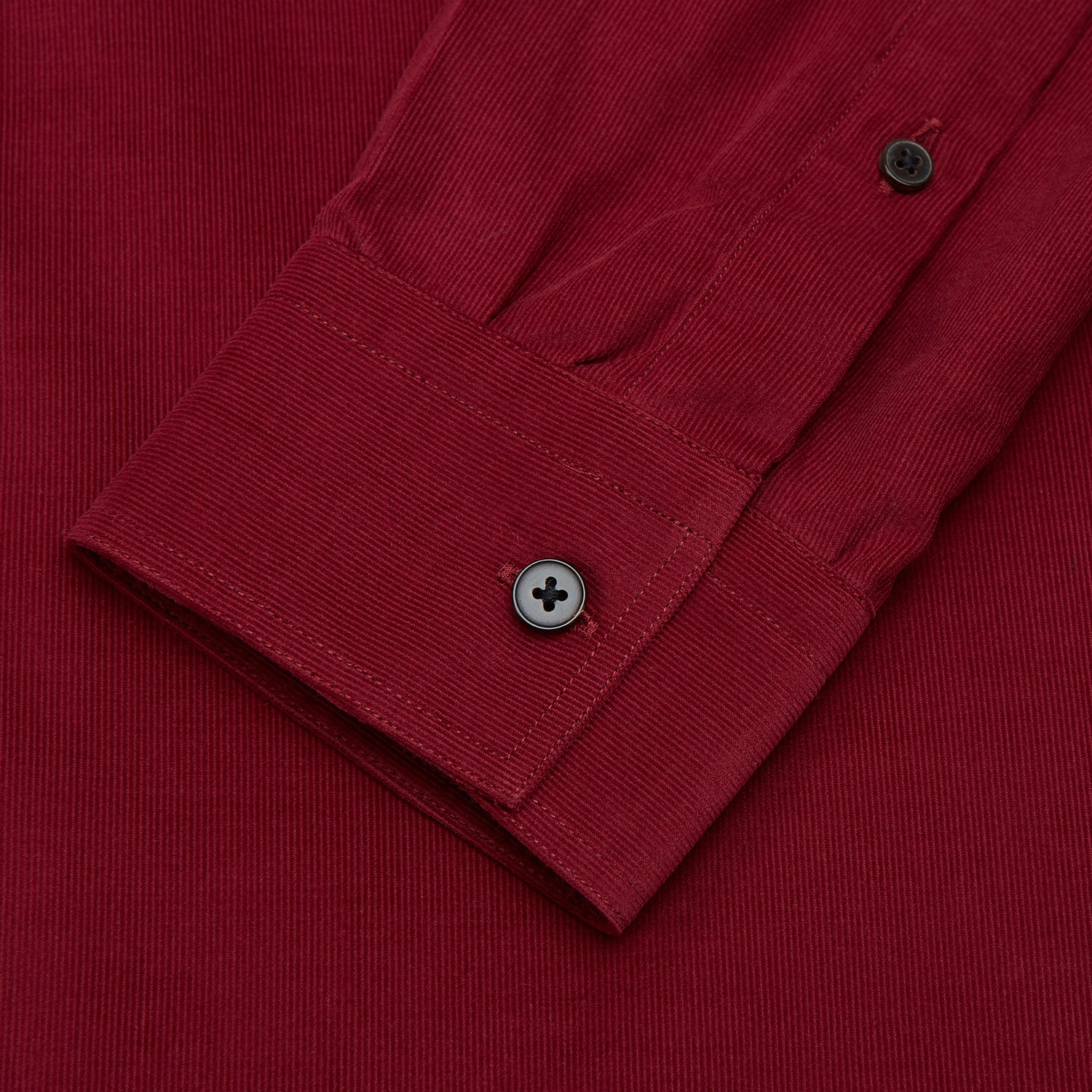 View 3 of product The Turnbull & Asser Burgundy Corduroy Officer Weekend Fit Shirt features a Dorset collar, long sleeves, one-button cuffs, and two chest pockets with buttoned flaps, shown laid flat on a white background.