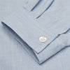 View 5 of product The Turnbull & Asser Holiday Fit Blue Cotton and Cashmere Blend Shirt features long sleeves, a classic collar, single chest pocket, and 1-button cuffs with white buttons, shown laid flat on a white background.