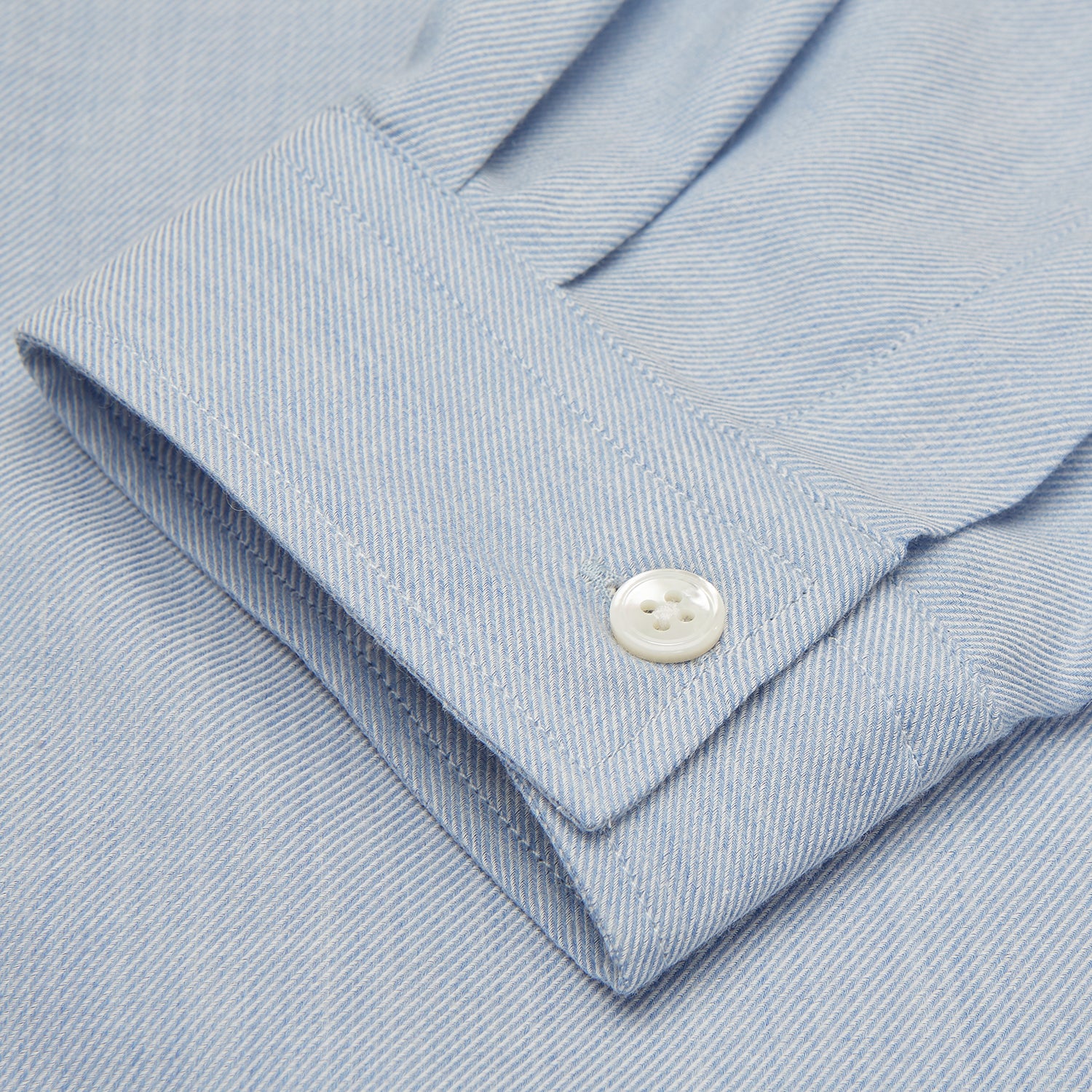 View 5 of product The Turnbull & Asser Holiday Fit Blue Cotton and Cashmere Blend Shirt features long sleeves, a classic collar, single chest pocket, and 1-button cuffs with white buttons, shown laid flat on a white background.