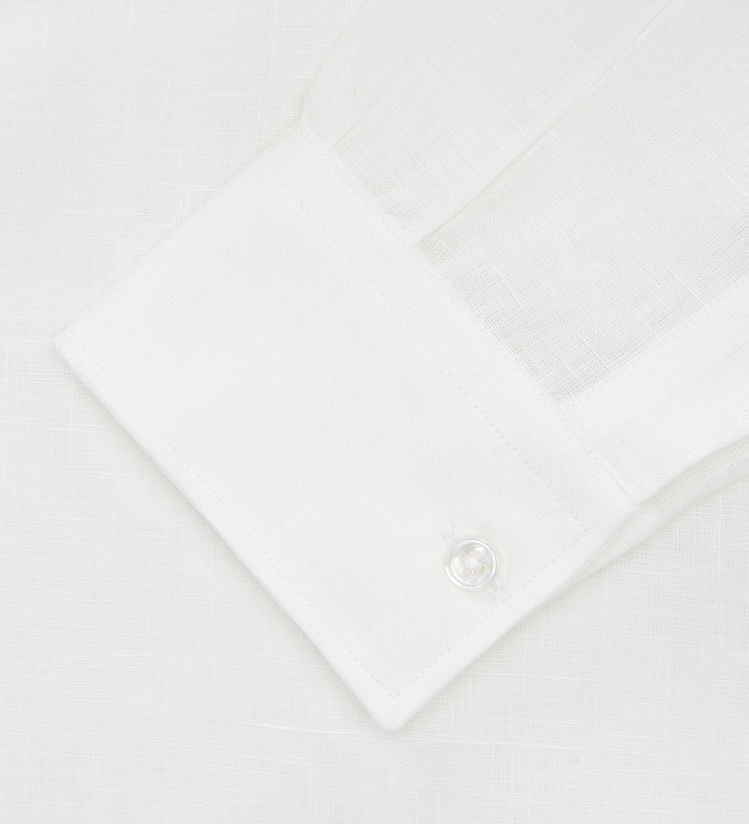 View 2 of product The Turnbull & Asser Cream Linen Weekend Fit Shirt features a Derby collar, 1-button cuffs, and single chest pocket, crafted from sustainable French linen. Shown laid flat on a white background.