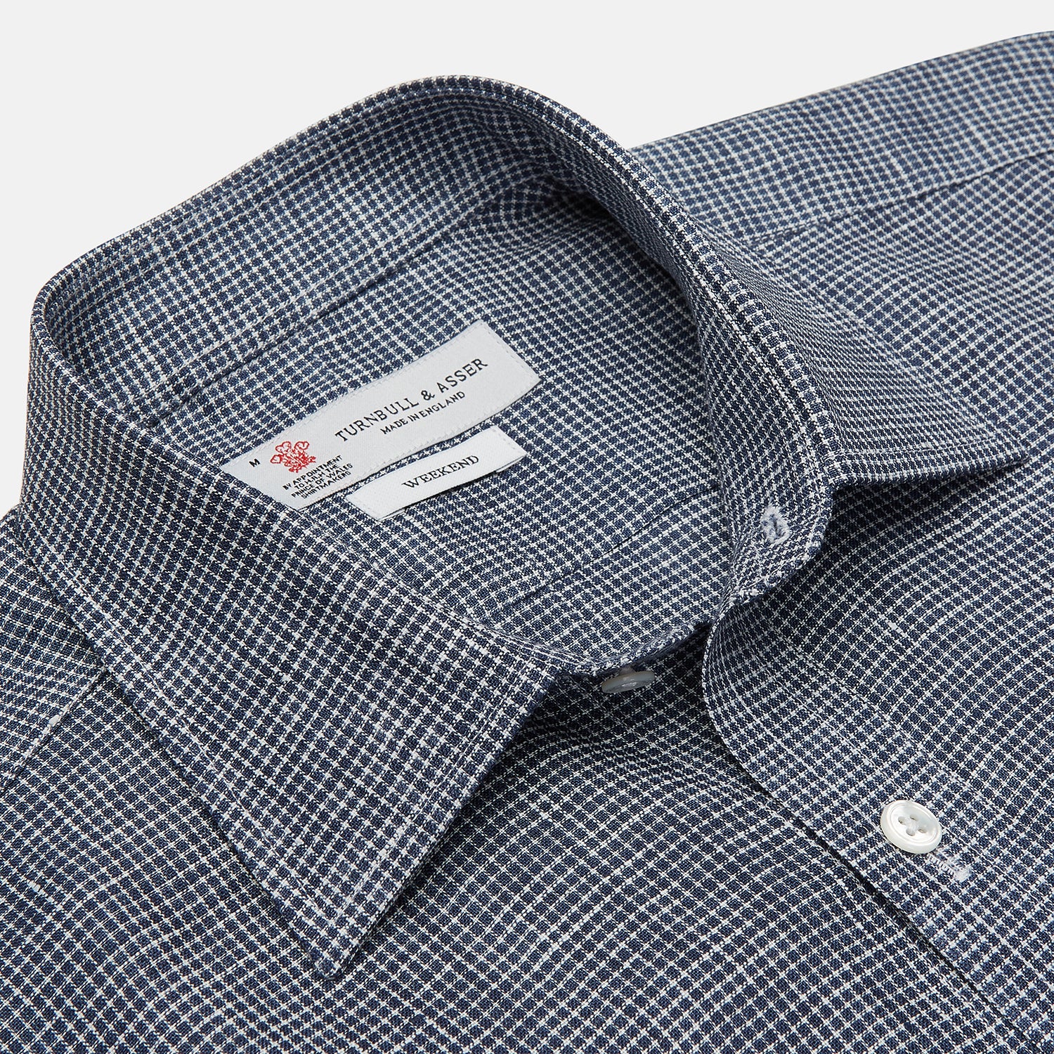 View 3 of product The Turnbull & Asser Weekend Fit Navy Check Linen Shirt features a Derby collar, left chest pocket, 1-button cuffs, and white buttons in textured microcheck fabric, shown laid flat on a white background.