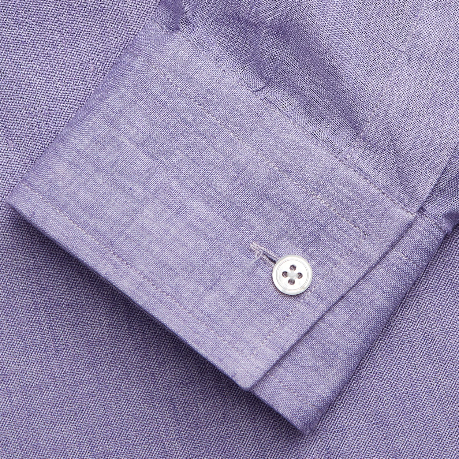 View 6 of product A man stands against a beige background wearing the Turnbull & Asser Lilac Weekend Fit Linen Blake Shirt with Stand Collar and 1-Button Cuffs, paired with dark pinstriped pants and brown sandals—a relaxed weekend look.
