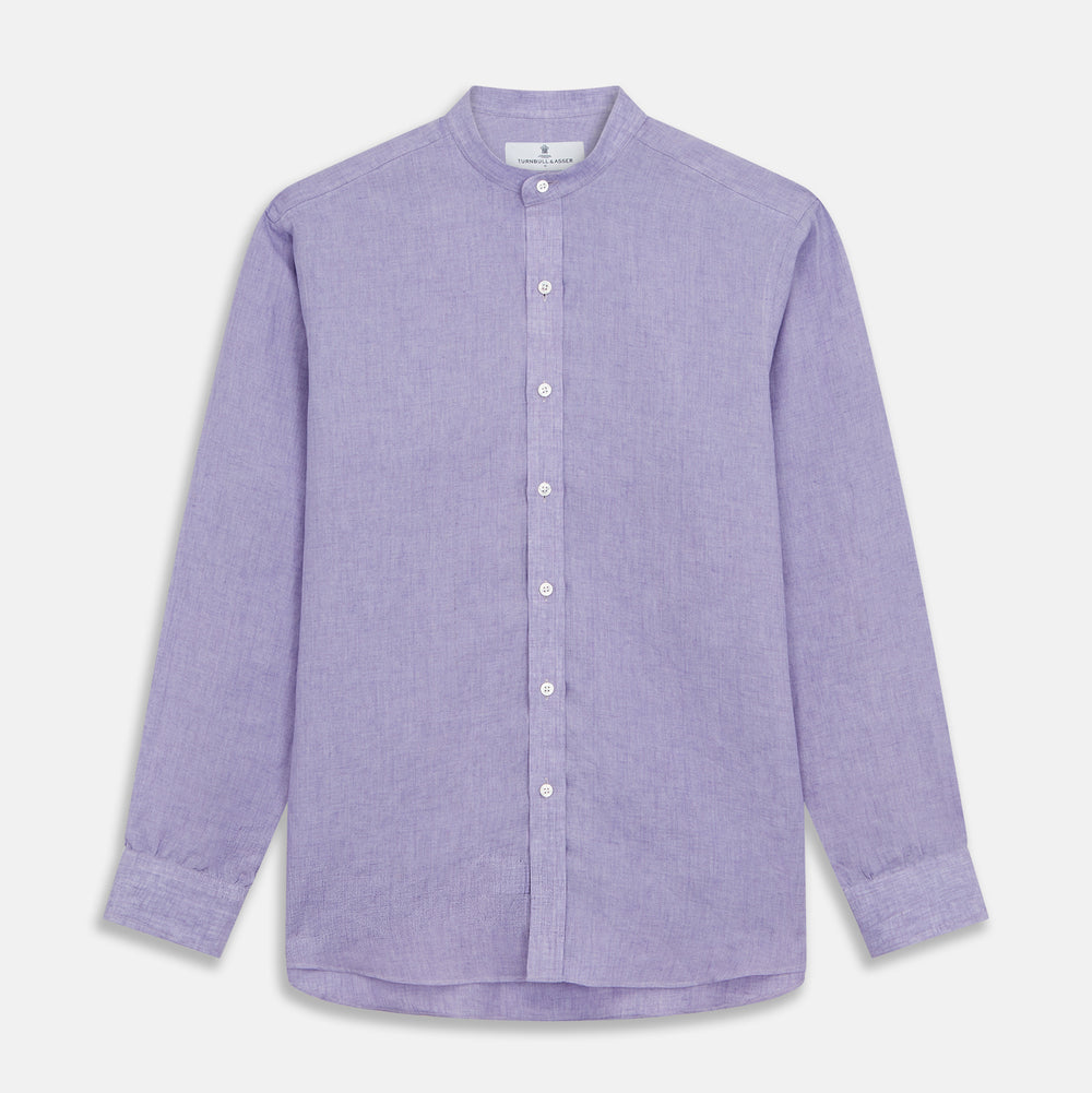 A man stands against a beige background wearing the Turnbull & Asser Lilac Weekend Fit Linen Blake Shirt with Stand Collar and 1-Button Cuffs, paired with dark pinstriped pants and brown sandals—a relaxed weekend look.