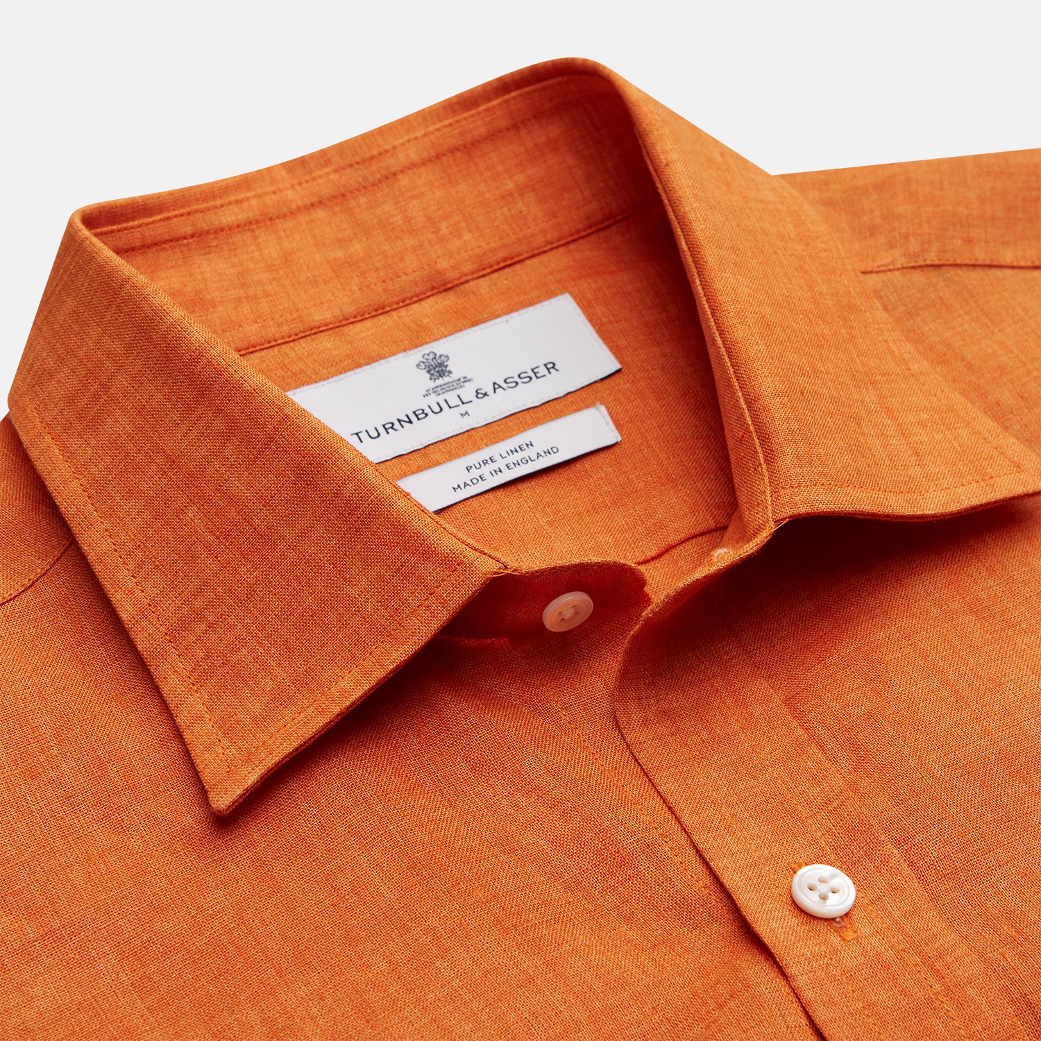 View 4 of product The Turnbull & Asser Orange Weekend Fit Linen Nevis Shirt features a Derby collar, long sleeves with 1-button cuffs, white buttons, and a chest pocket, shown flat against a white background.