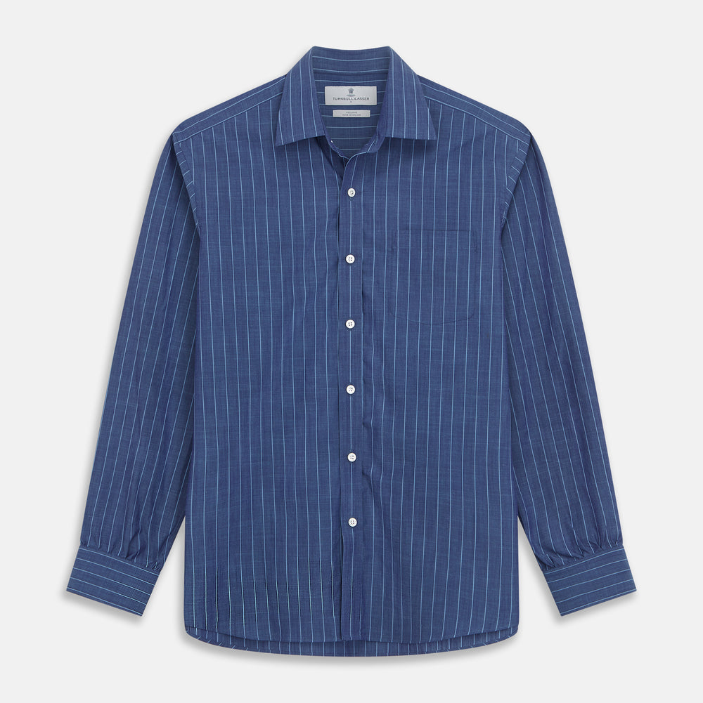 Close-up of a person wearing the Turnbull & Asser Blue Stripe Weekend Fit Nevis Shirt with Derby Collar and 1-Button Cuffs under a dark pinstripe blazer, focusing on the collar and upper chest. The face is partially out of frame.