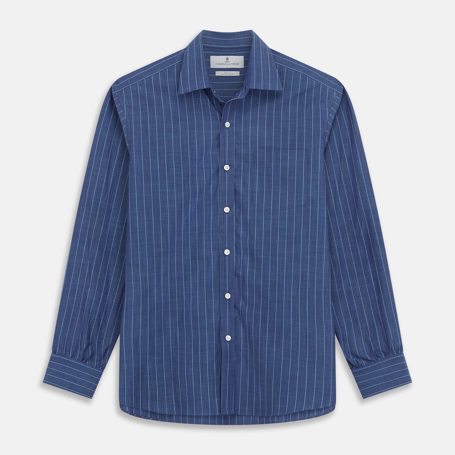 View 2 of product Close-up of a person wearing the Turnbull & Asser Blue Stripe Weekend Fit Nevis Shirt with Derby Collar and 1-Button Cuffs under a dark pinstripe blazer, focusing on the collar and upper chest. The face is partially out of frame.