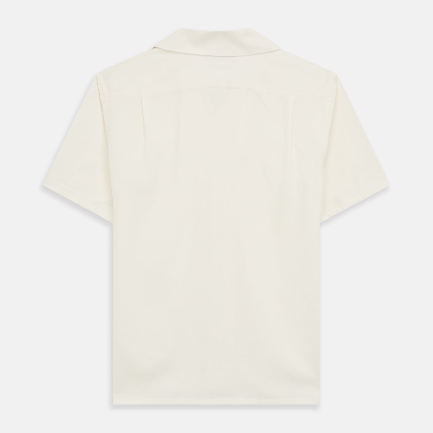 View 5 of product The Turnbull & Asser Cream Holiday Fit Silk Phillips Shirt features a revere collar, short sleeves, and three front pockets, shown flat on a white background.
