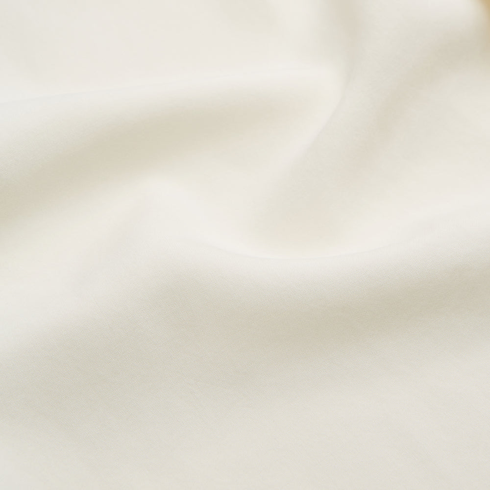 The Turnbull & Asser Cream Holiday Fit Silk Phillips Shirt features a revere collar, short sleeves, and three front pockets, shown flat on a white background.