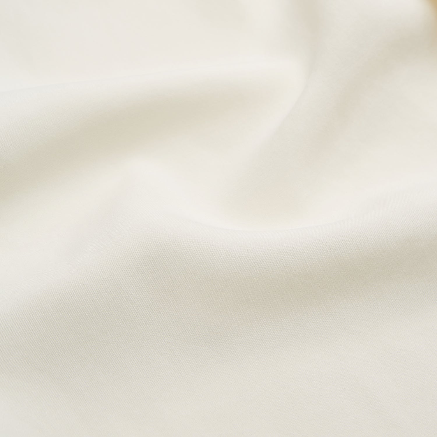 View 4 of product The Turnbull & Asser Cream Holiday Fit Silk Phillips Shirt features a revere collar, short sleeves, and three front pockets, shown flat on a white background.