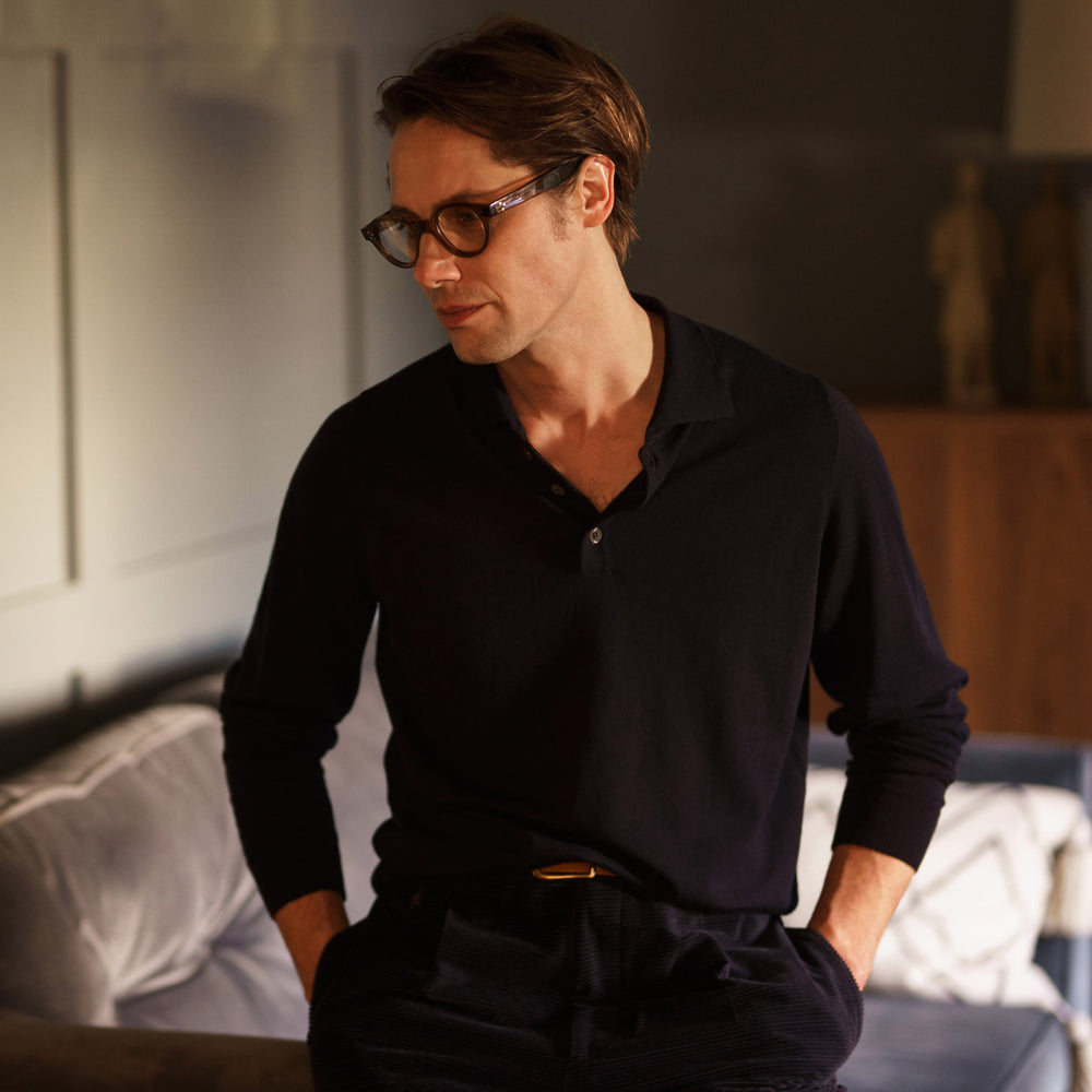 The Navy Merino Wool Cecil Rugby Polo Shirt by Turnbull & Asser features long sleeves, a collar, and a three-button placket—a timeless menswear staple laid flat on a white background.