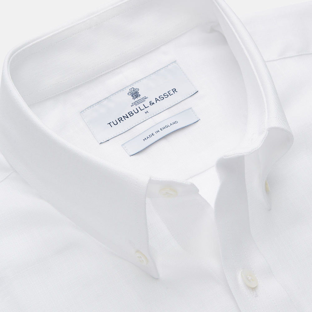 The Turnbull & Asser White Chambray Weekend Fit Shirt features a Dorset collar, 1-button cuffs, and a front pocket. Its clean design stands out against a plain white background—perfect for fans of classic Weekend Fit shirts.