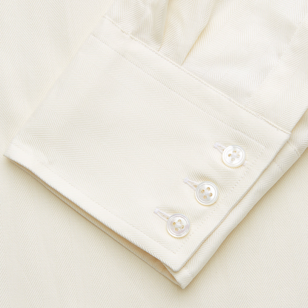 The Turnbull & Asser Cream Weekend Fit Larkin Shirt features a Dorset collar, 3-button cuffs, and two button-flap chest pockets in soft herringbone cotton, displayed flat on a white background.