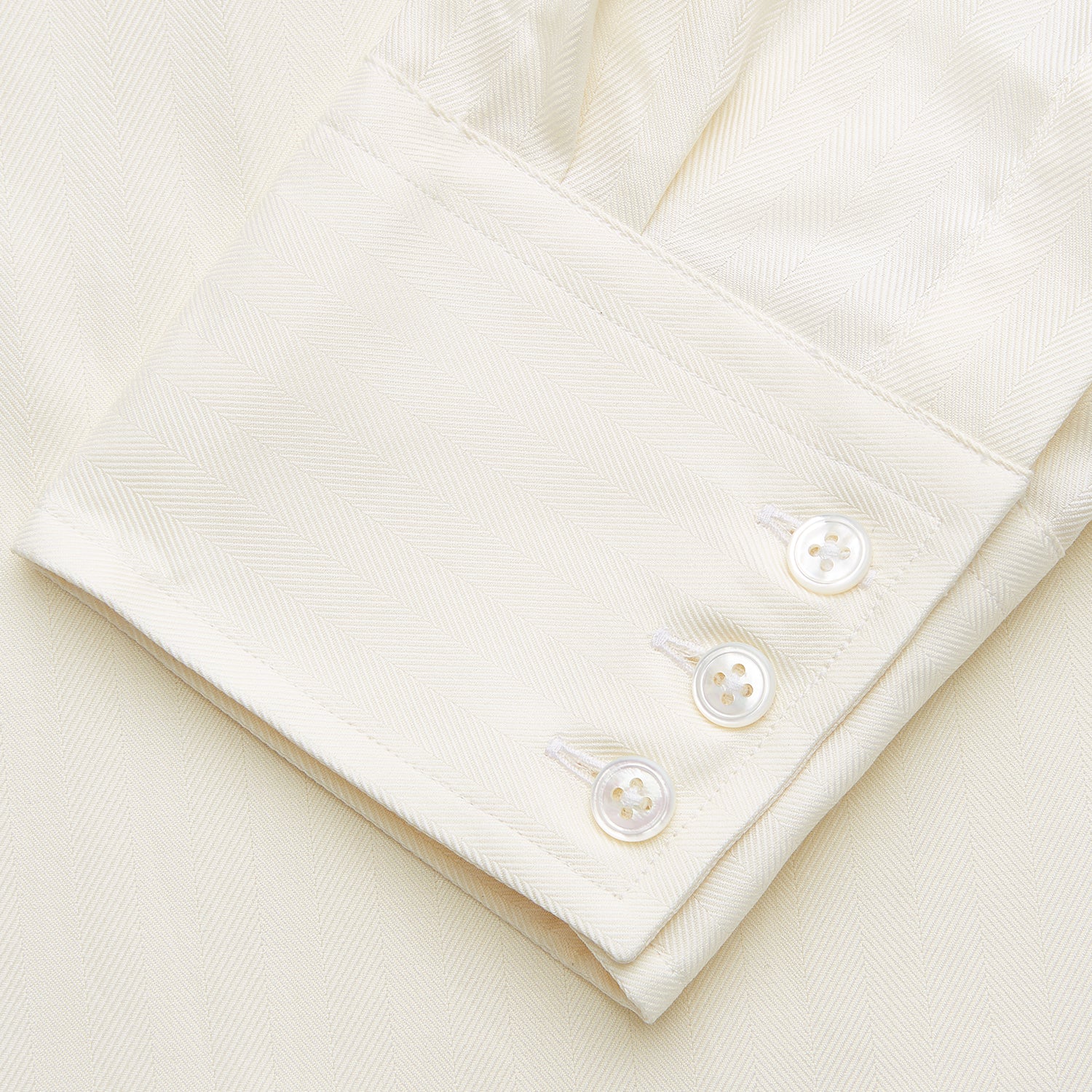 View 3 of product The Turnbull & Asser Cream Weekend Fit Larkin Shirt features a Dorset collar, 3-button cuffs, and two button-flap chest pockets in soft herringbone cotton, displayed flat on a white background.