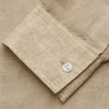 View 5 of product A man with a bald head and trimmed beard wears the Turnbull & Asser Beige Weekend Fit Linen Blake Shirt with stand collar and 1-button cuffs, standing calmly against a matching beige background.