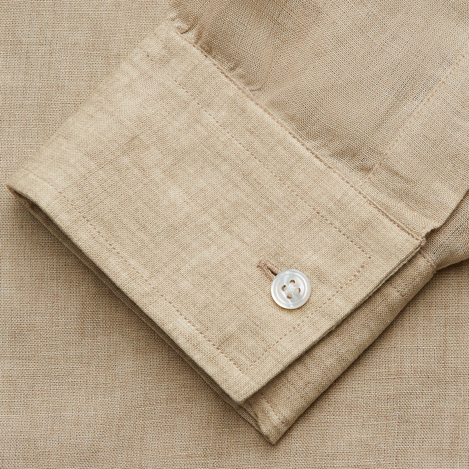 View 5 of product A man with a bald head and trimmed beard wears the Turnbull & Asser Beige Weekend Fit Linen Blake Shirt with stand collar and 1-button cuffs, standing calmly against a matching beige background.