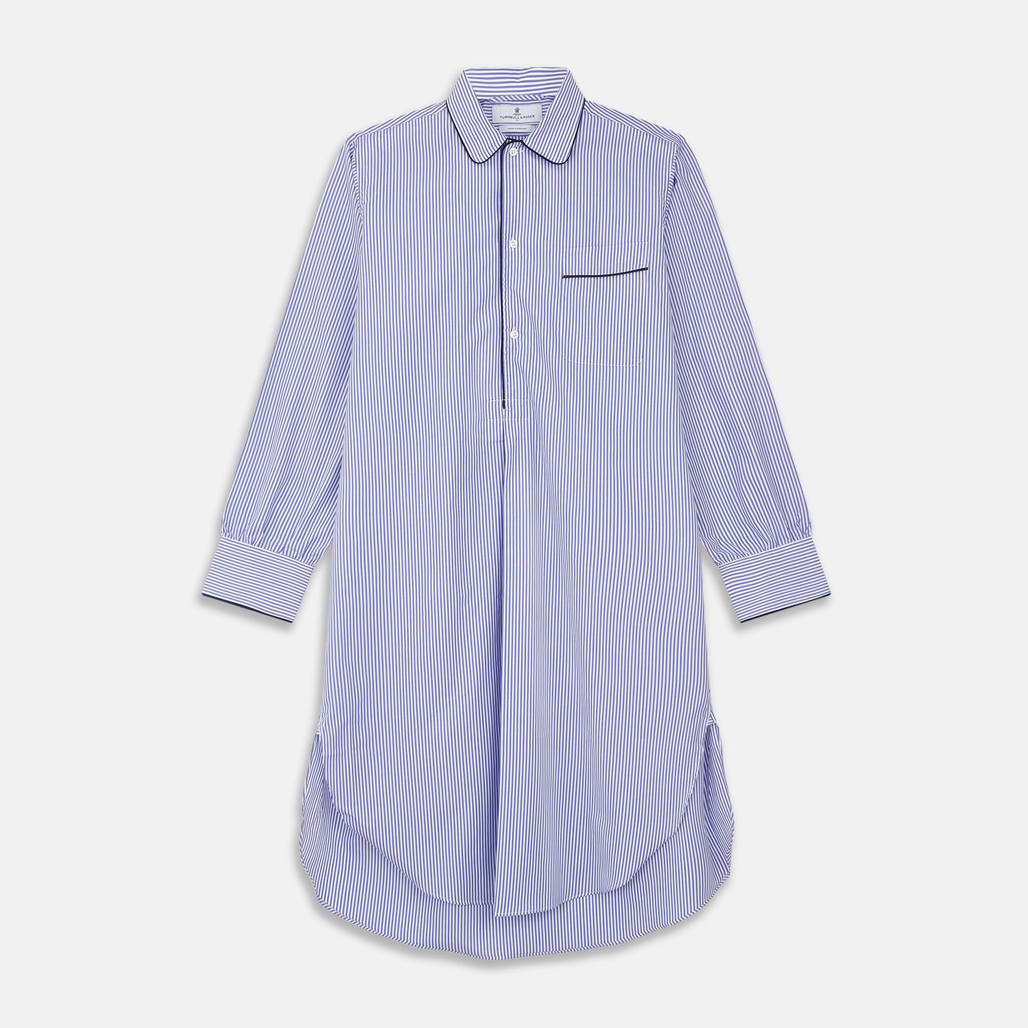 View 1 of product The Turnbull & Asser Blue Bengal Stripe Piped Cotton Nightshirt features long sleeves, a pointed collar, dark-trimmed pocket, curved hem, button details, and cuffed sleeves for an elegant look.