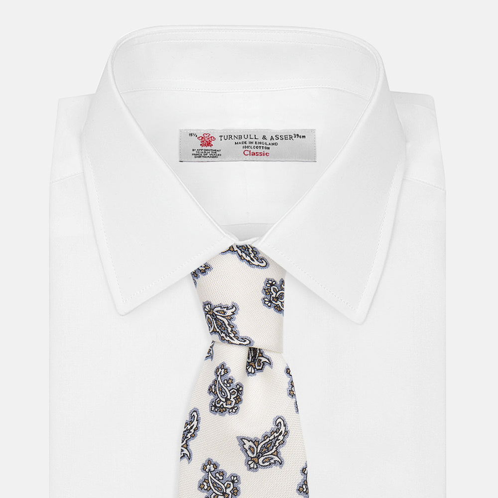 The Ecru Paisley Floral Cotton Silk Blend Tie by Turnbull & Asser features a paisley floral pattern, elegantly displayed and neatly rolled on a plain white background.