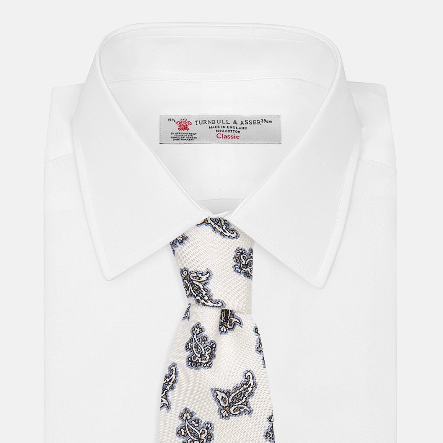 View 5 of product The Ecru Paisley Floral Cotton Silk Blend Tie by Turnbull & Asser features a paisley floral pattern, elegantly displayed and neatly rolled on a plain white background.