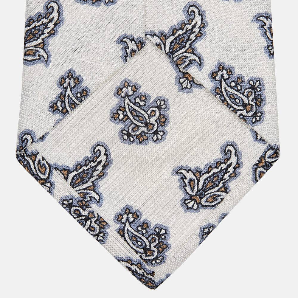 The Ecru Paisley Floral Cotton Silk Blend Tie by Turnbull & Asser features a paisley floral pattern, elegantly displayed and neatly rolled on a plain white background.