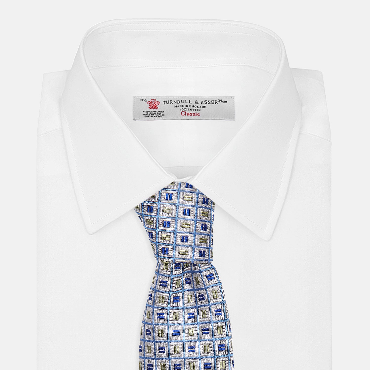 View 4 of product A Turnbull & Asser Blue and Yellow Geometric Silk Jacquard Tie is shown rolled up on a plain light background.