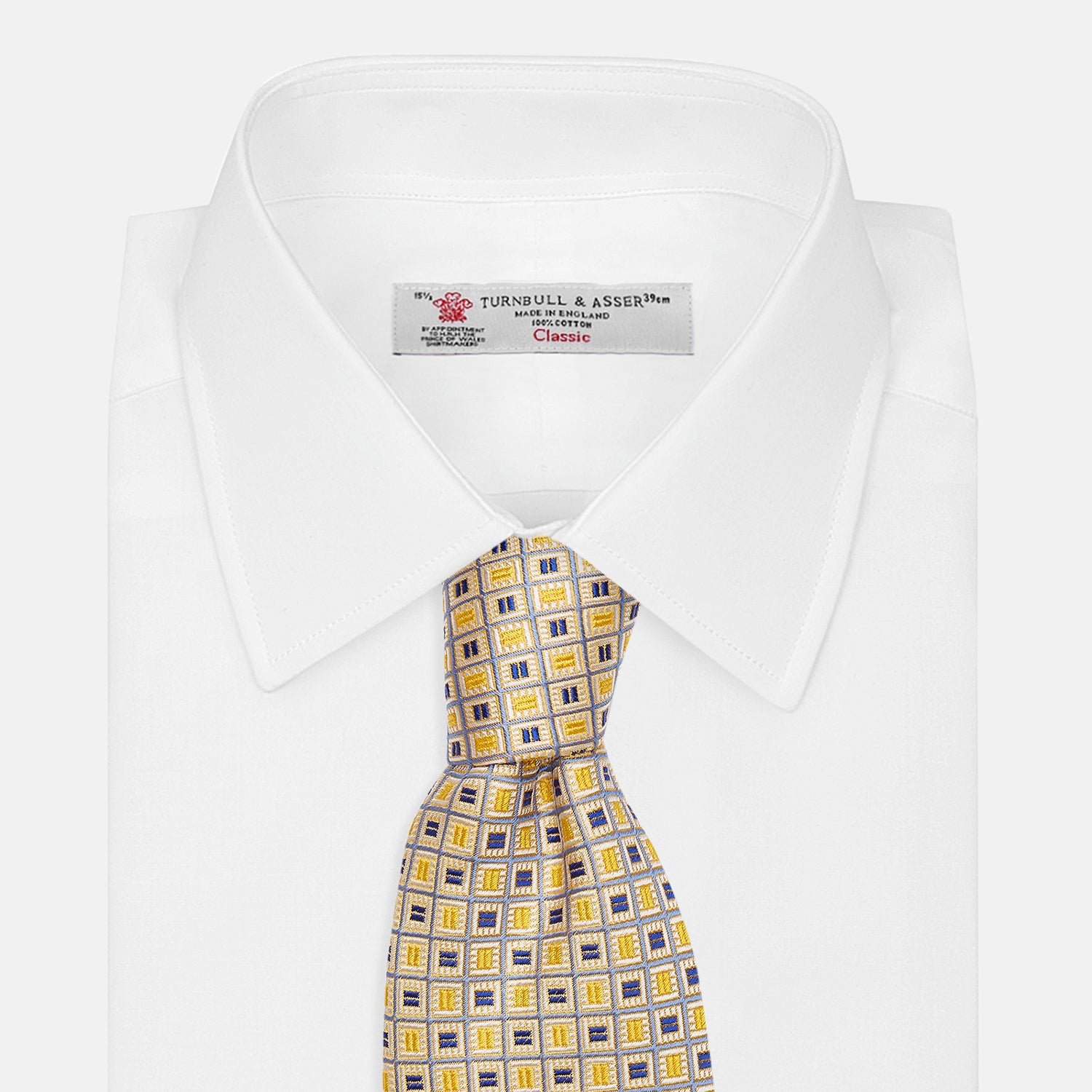 View 4 of product The Turnbull & Asser Yellow Fine Square Slub Silk Tie features a soft yellow jacquard with a subtle texture, decorated with a repeating blue and white diamond pattern, shown rolled up on a plain white background.
