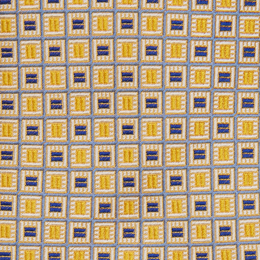 The Turnbull & Asser Yellow and Navy Geometric Silk Jacquard Tie features a striking square pattern on a light background, ideal for formal occasions, shown rolled up against a plain white surface.