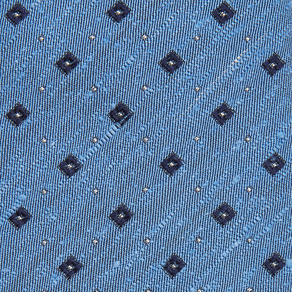 The Turnbull & Asser Dark Blue Fine Square Slub Silk Tie, featuring an elegant square pattern and subtle texture, is shown rolled-up against a plain white background.