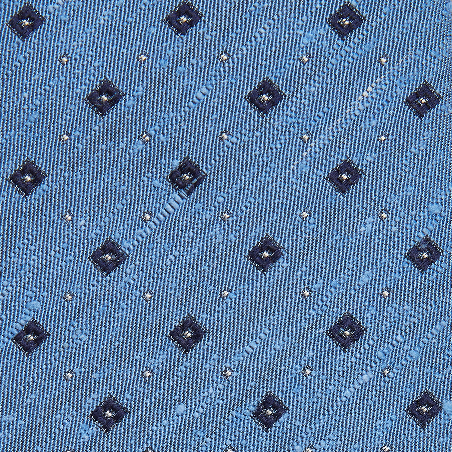 View 2 of product The Turnbull & Asser Dark Blue Fine Square Slub Silk Tie, featuring an elegant square pattern and subtle texture, is shown rolled-up against a plain white background.