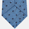 View 3 of product The Turnbull & Asser Dark Blue Fine Square Slub Silk Tie, featuring an elegant square pattern and subtle texture, is shown rolled-up against a plain white background.