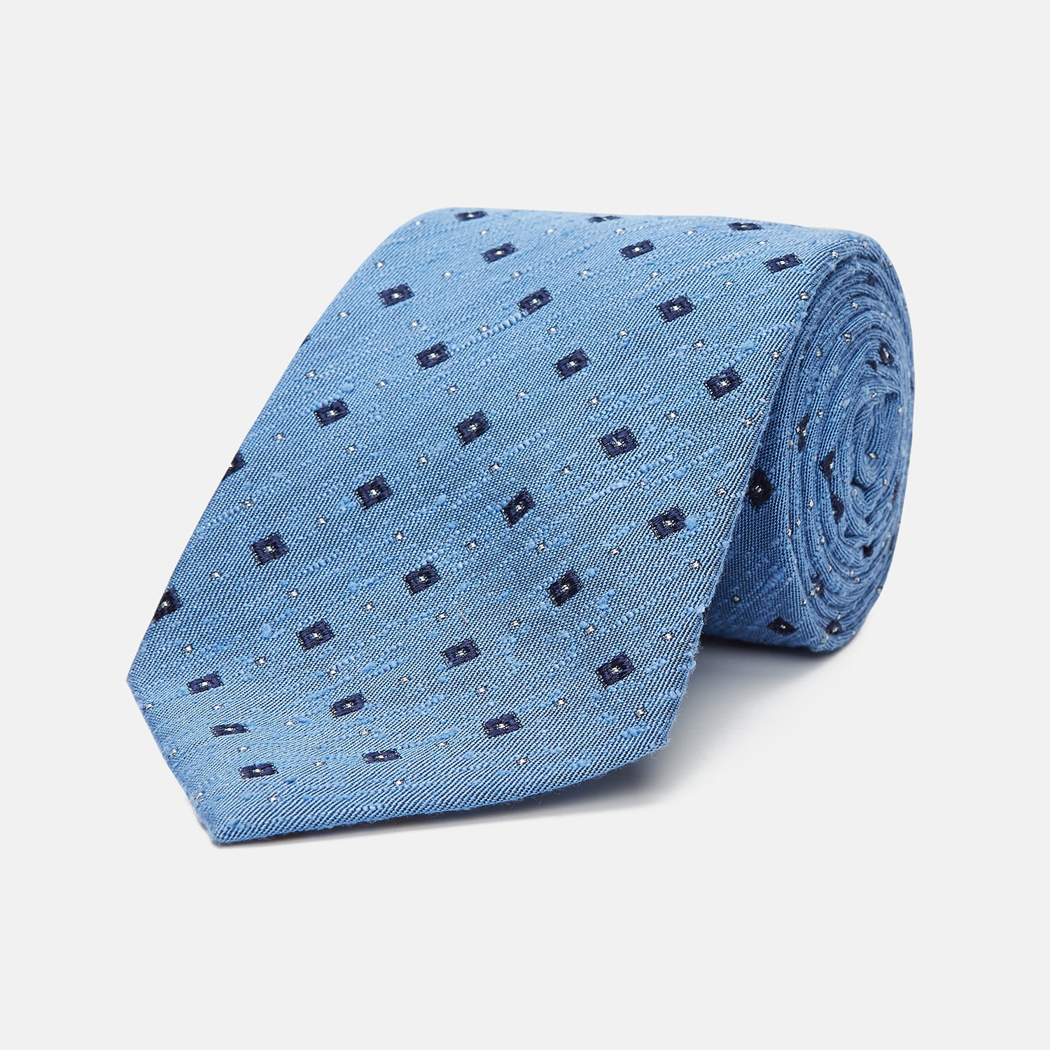 View 1 of product The Turnbull & Asser Dark Blue Fine Square Slub Silk Tie, featuring an elegant square pattern and subtle texture, is shown rolled-up against a plain white background.