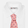 View 4 of product The Turnbull & Asser Pink Fine Square Slub Silk Tie features a pastel pink silk jacquard with blue and white geometric squares, shown rolled up on a plain white background.
