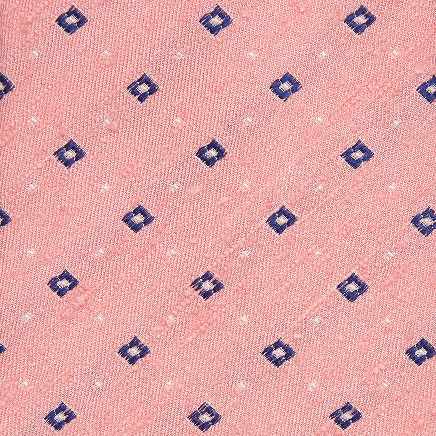 View 2 of product The Turnbull & Asser Pink Fine Square Slub Silk Tie features a pastel pink silk jacquard with blue and white geometric squares, shown rolled up on a plain white background.
