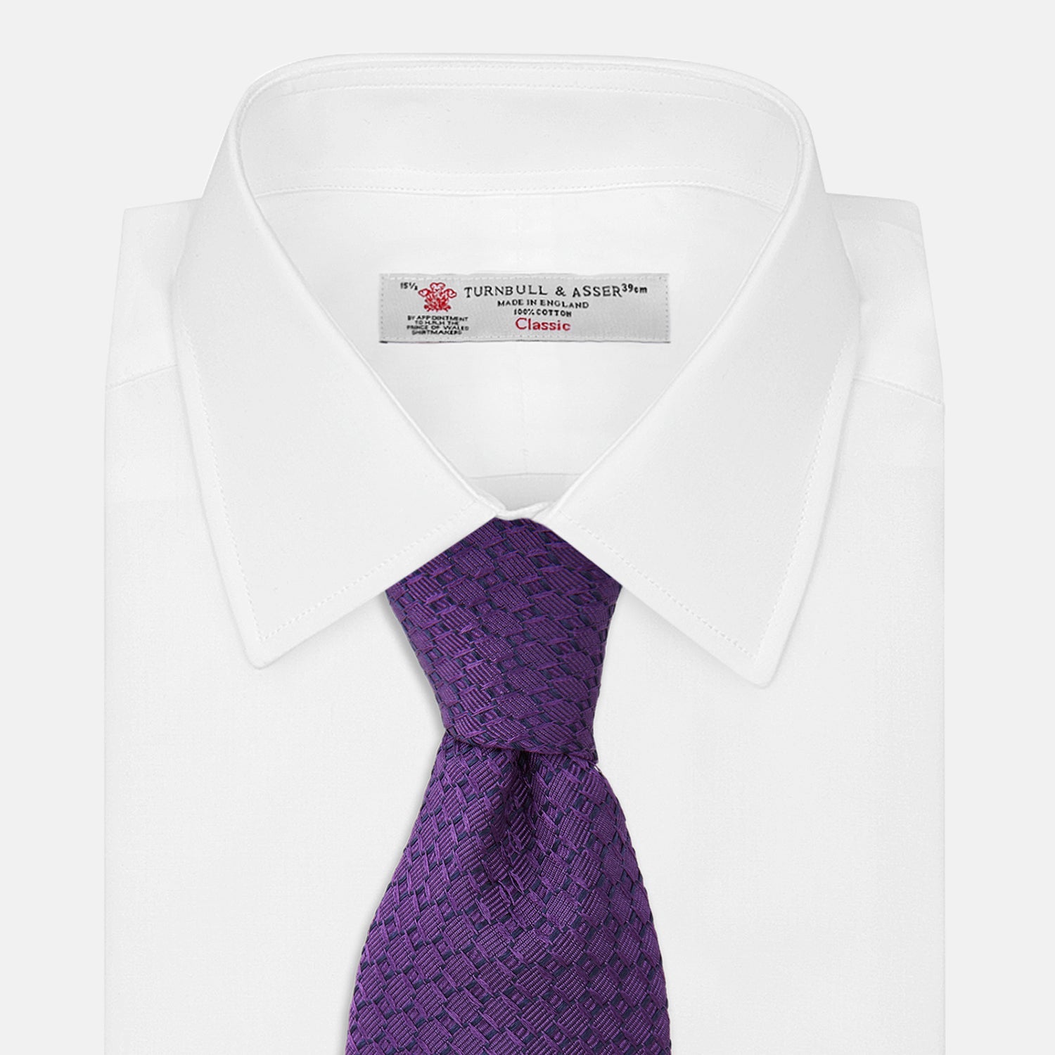 View 2 of product The Turnbull & Asser Purple Abstract Tonal Silk Jacquard Tie, featuring a textured geometric pattern, is shown rolled up against a white background—an ideal choice to elevate any formal outfit.