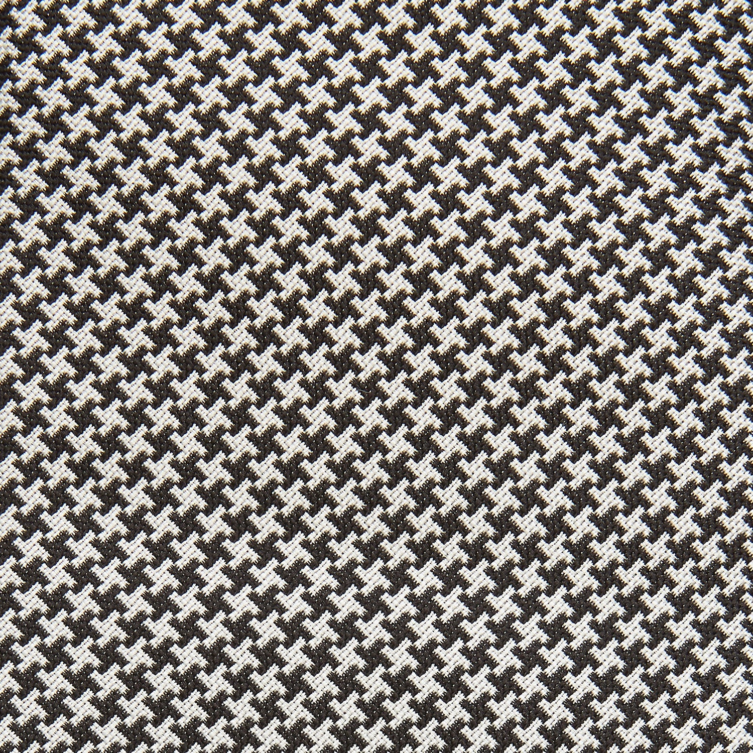 View 2 of product The Turnbull & Asser Fine Puppytooth Monochrome Silk Tie, in classic black and white, features a refined pattern and is shown rolled on a plain white background—ideal for enhancing any formal outfit.