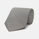 The Turnbull & Asser Fine Puppytooth Monochrome Silk Tie, in classic black and white, features a refined pattern and is shown rolled on a plain white background—ideal for enhancing any formal outfit.