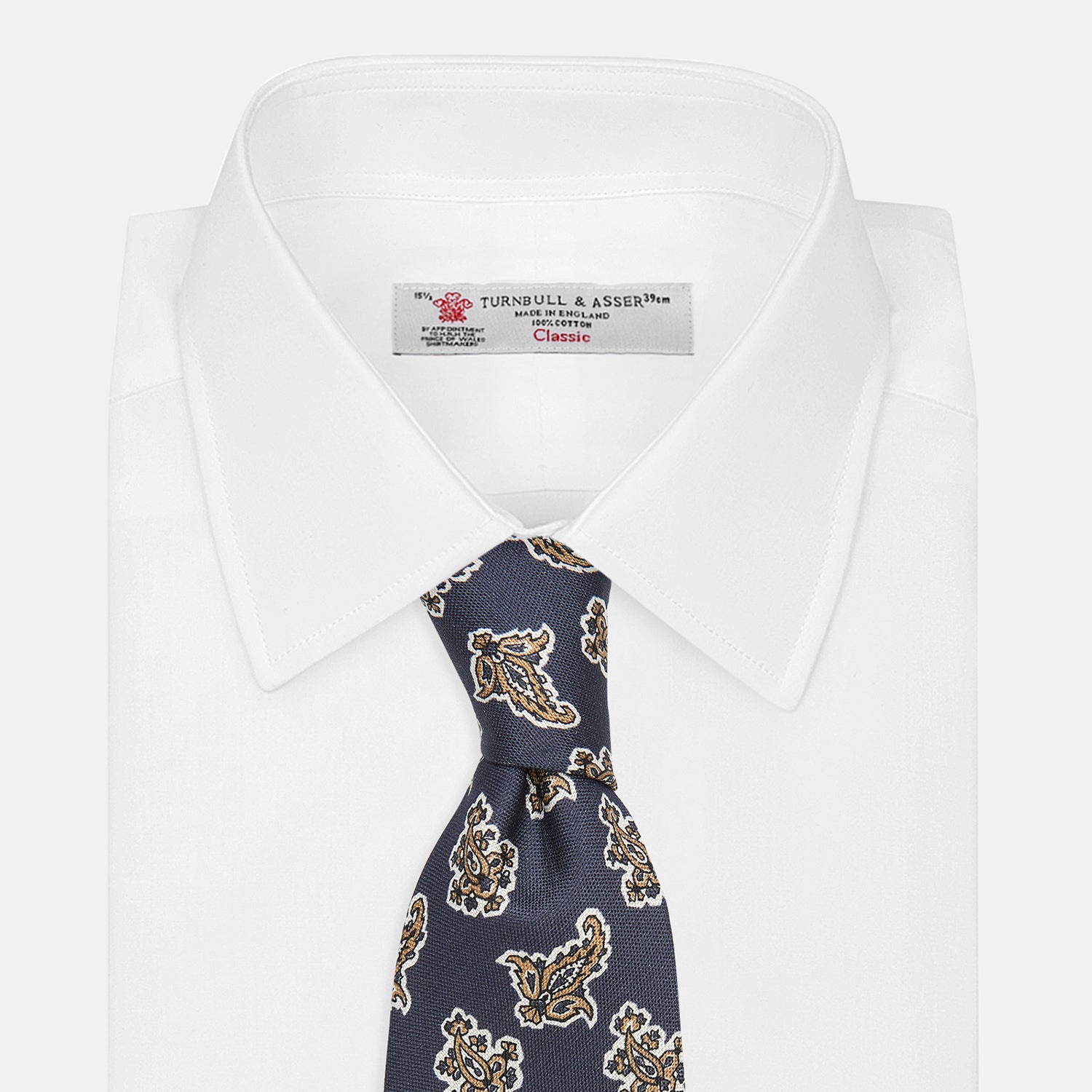 View 3 of product The Turnbull & Asser Navy Paisley Floral Cotton Silk Blend Tie features beige and light blue paisley motifs on navy, with one end rolled.
