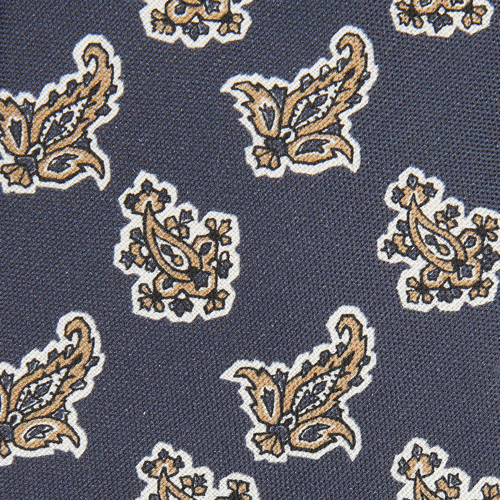 The Turnbull & Asser Navy Paisley Floral Cotton Silk Blend Tie features beige and light blue paisley motifs on navy, with one end rolled.