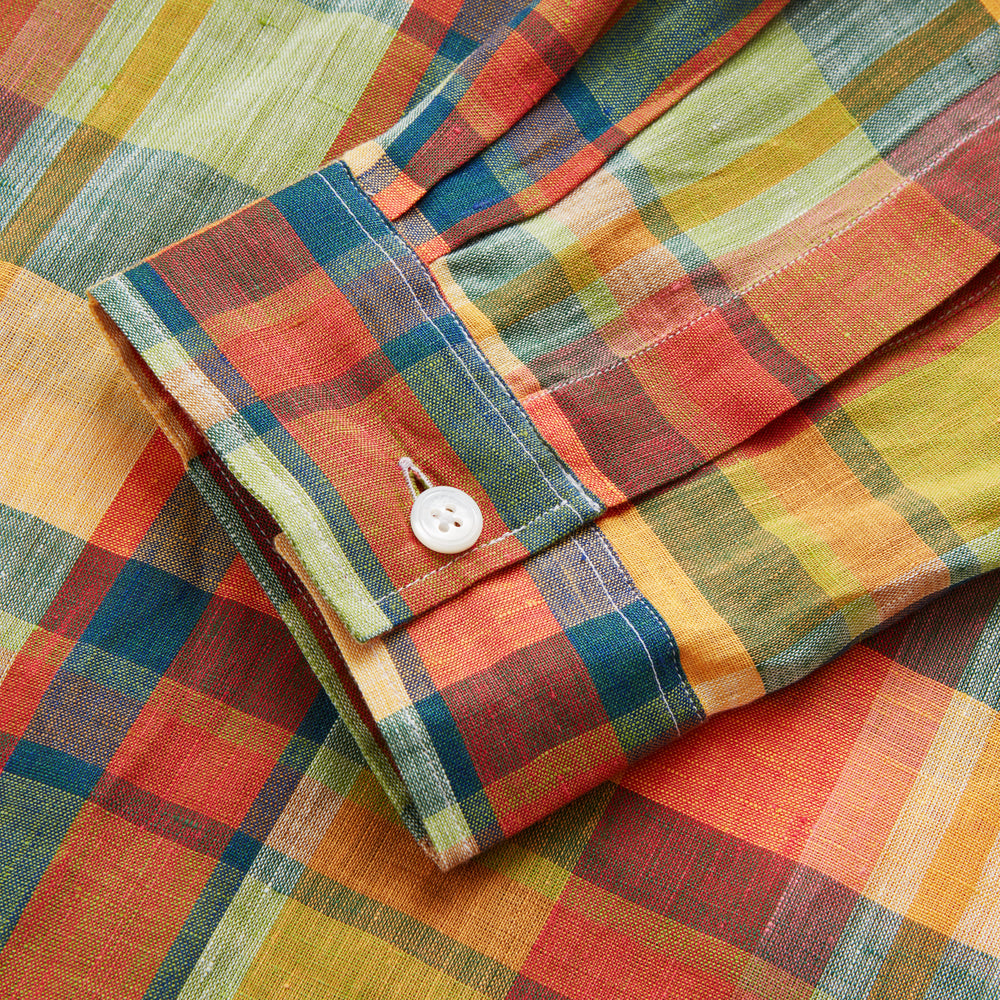 Turnbull & Asser's Orange Madras Check Holiday Fit Long Sleeve Linen Shirt features a bold plaid in orange, yellow, green, and blue with a revere collar and 1-button cuff—ideal for effortless holiday style. Laid flat on white background.