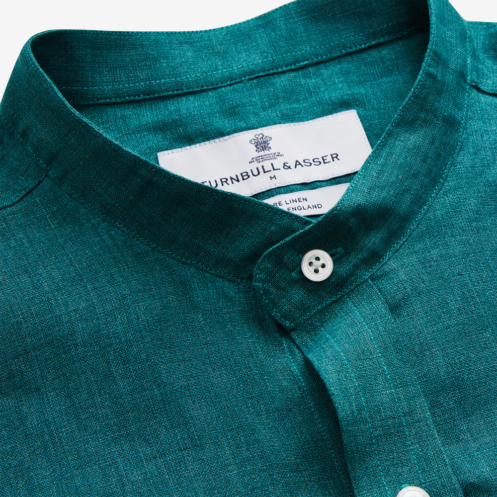 The Turnbull & Asser Teal Weekend Fit Long Sleeve Linen Shirt features a stand collar, 1-button cuffs, white buttons, and a relaxed fit, shown on a plain white background.