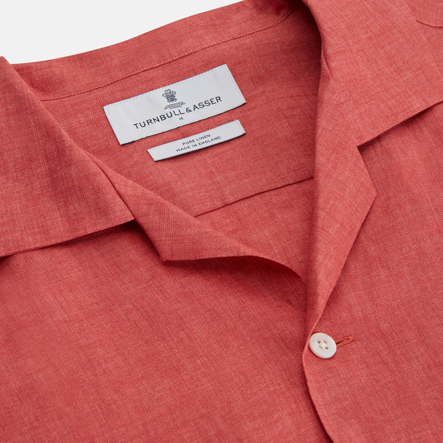 View 3 of product The Turnbull & Asser Crimson Delave Linen Holiday Fit Shirt features a solid brick-red hue, short sleeves, single chest pocket, and revere collar—perfect resort wear—shown laid flat on white.