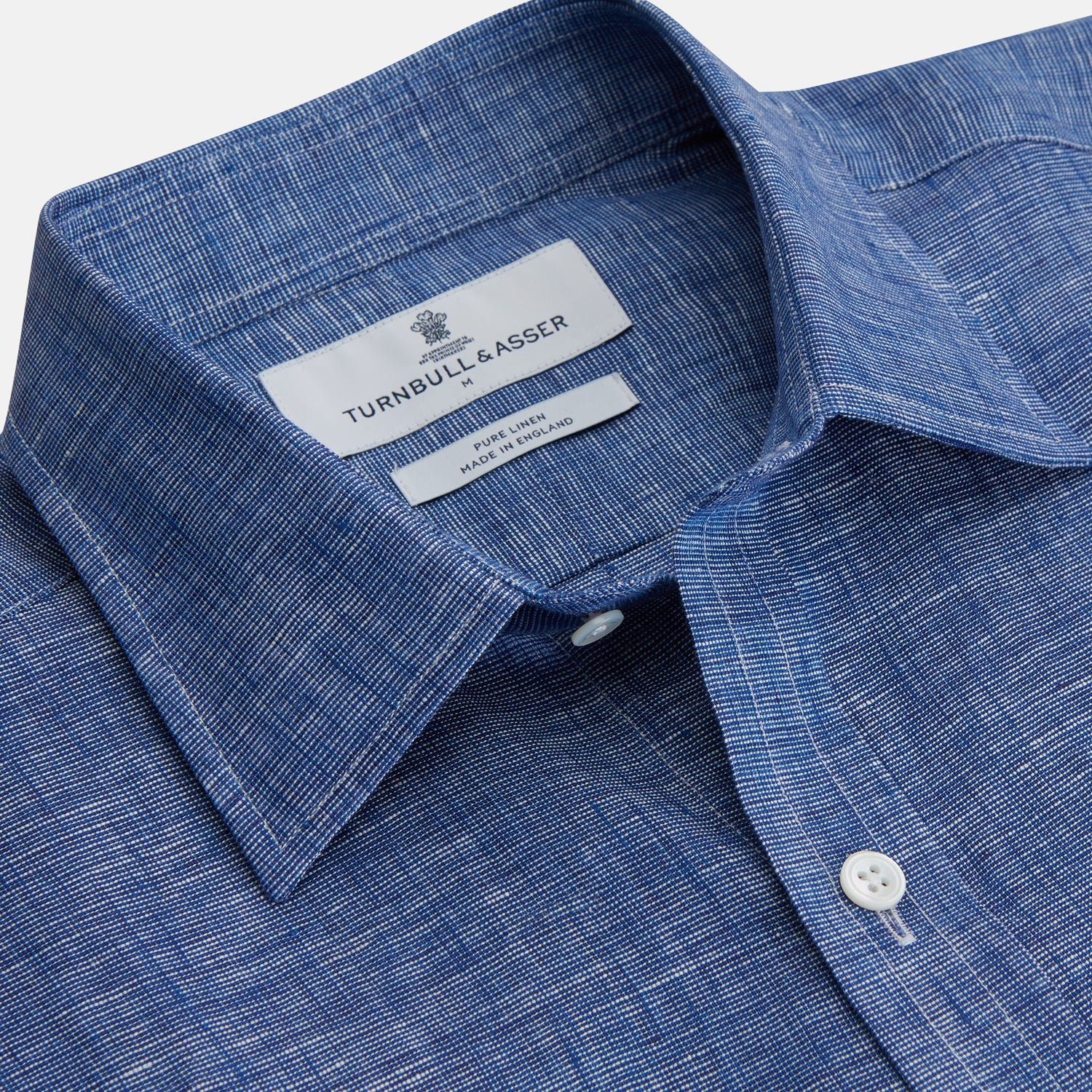 View 3 of product The Indigo Linen Weekend Fit Shirt with Derby Collar by Turnbull & Asser, shown flat on a white background, features long sleeves, white buttons, and buttoned cuffs—ideal for pairing with a classic suit or for casual wear.