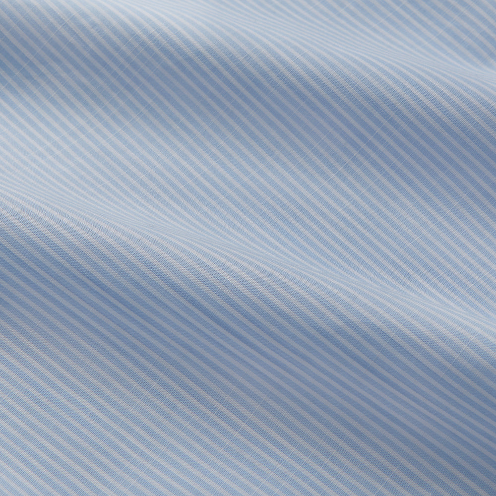 The Turnbull & Asser Sky Blue Chambray Stripe Weekend Fit Shirt features a Dorset collar, long sleeves, and two button-flap chest pockets, offering a relaxed look. Displayed on a plain white background.