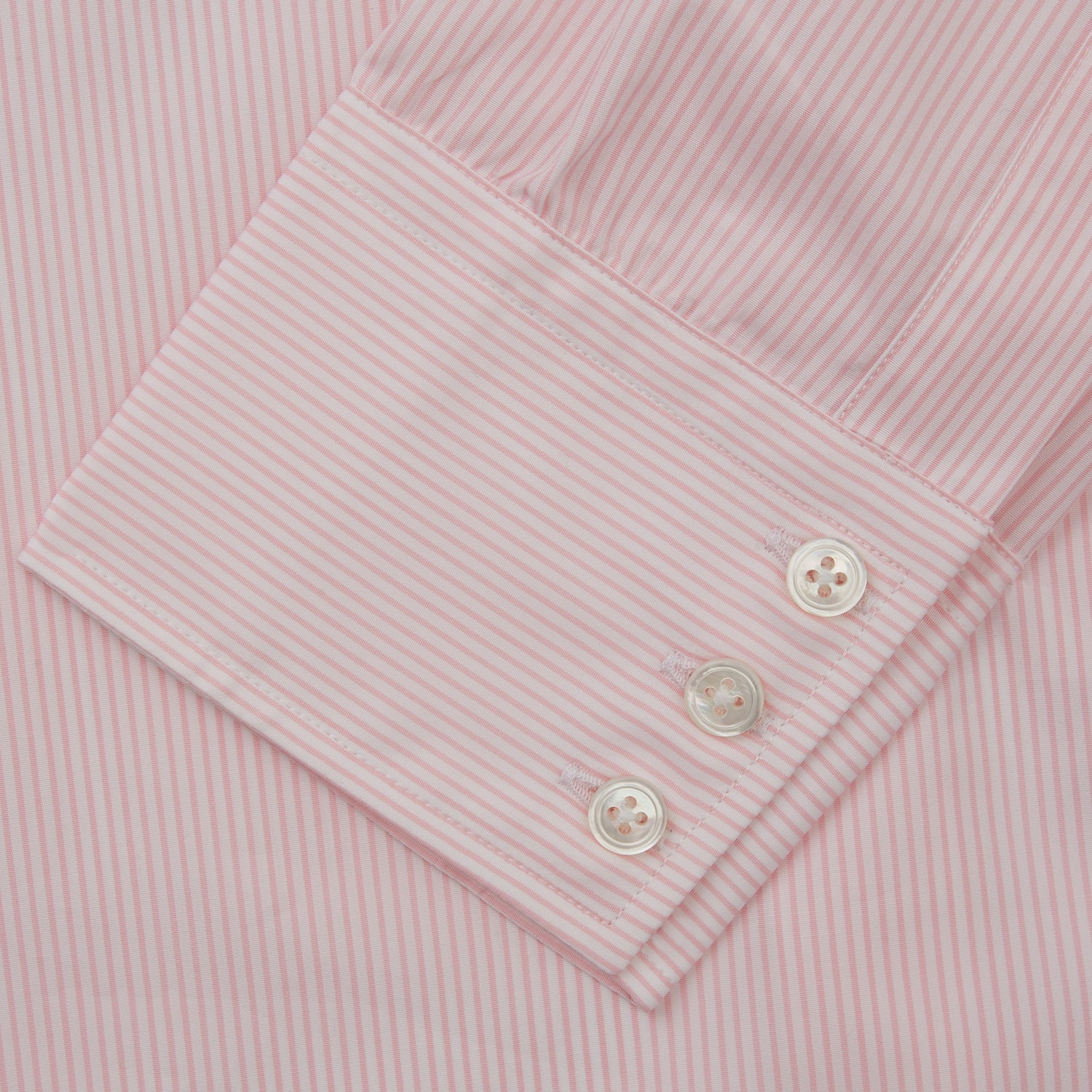 View 4 of product The Pink Fine Stripe Regular Fit Shirt with T&A Collar by Turnbull & Asser is a light pink, long-sleeve poplin shirt made from Italian cotton, featuring white buttons and shown flat on a white background.