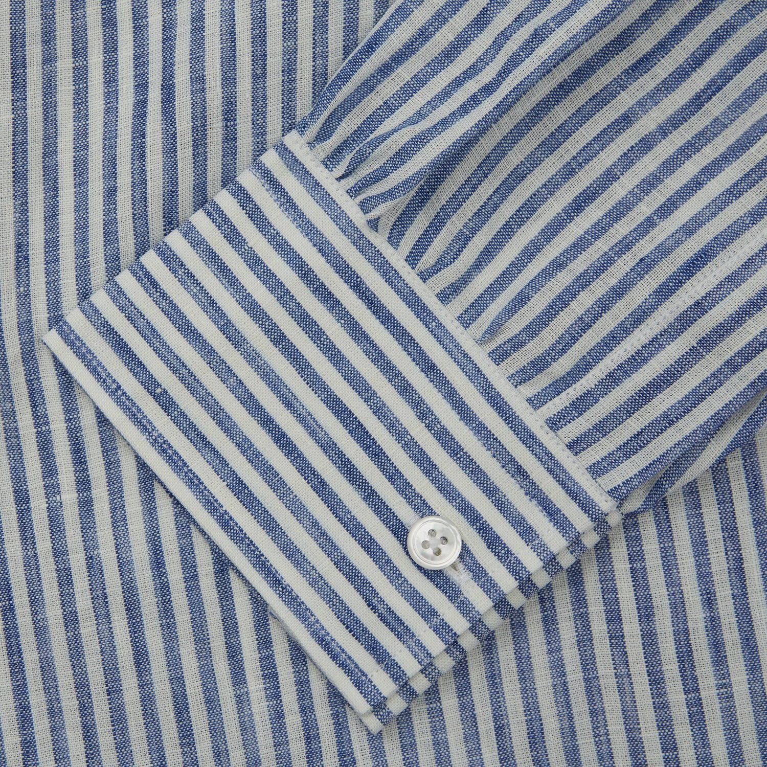 View 4 of product The Turnbull & Asser Sky Blue Linen Stripe Weekend Fit Shirt features blue and white vertical stripes, a Derby collar, and buttoned cuffs—ideal for pairing with classic cotton suits or other Weekend Fit shirts.