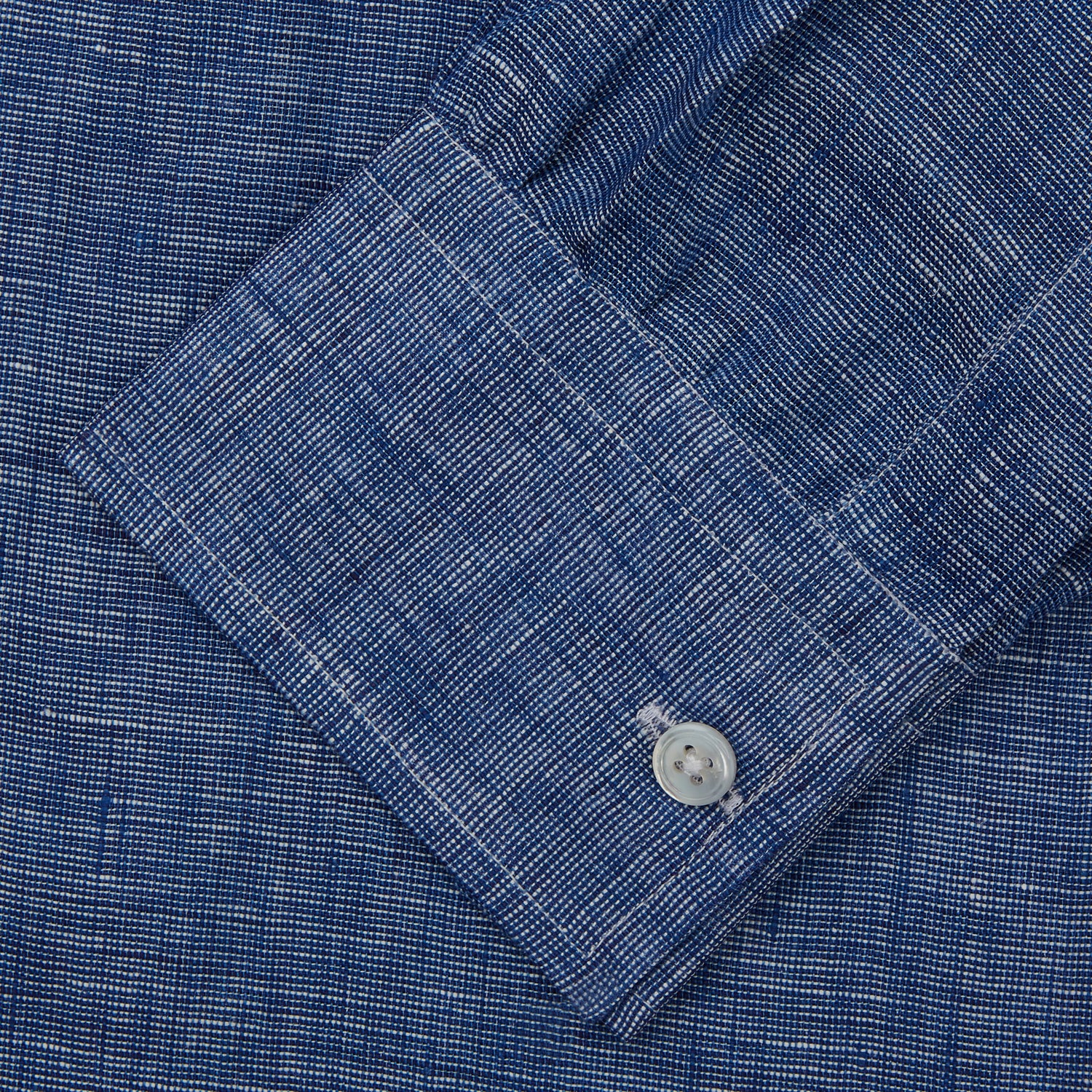 View 4 of product The Indigo Linen Weekend Fit Shirt with Derby Collar by Turnbull & Asser, shown flat on a white background, features long sleeves, white buttons, and buttoned cuffs—ideal for pairing with a classic suit or for casual wear.