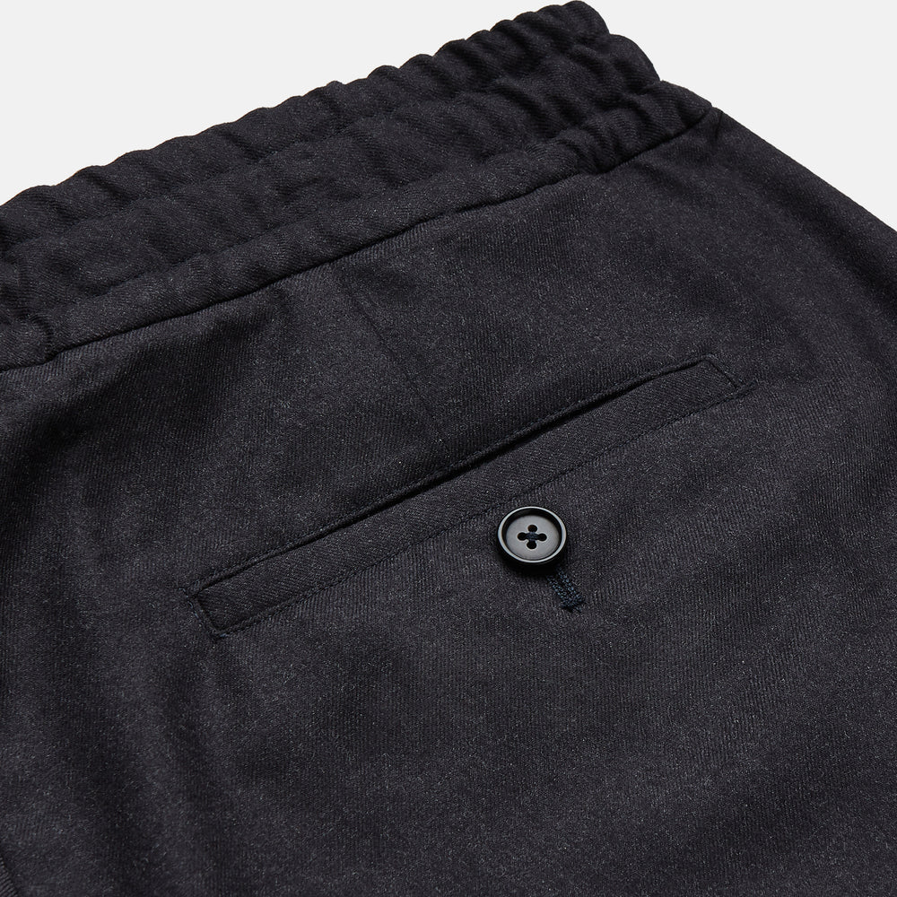 Turnbull & Asser Charcoal Tailored Drawstring Trousers in wool flannel, featuring an elastic waistband, straight legs, and side pockets, shown laid flat on a white background.