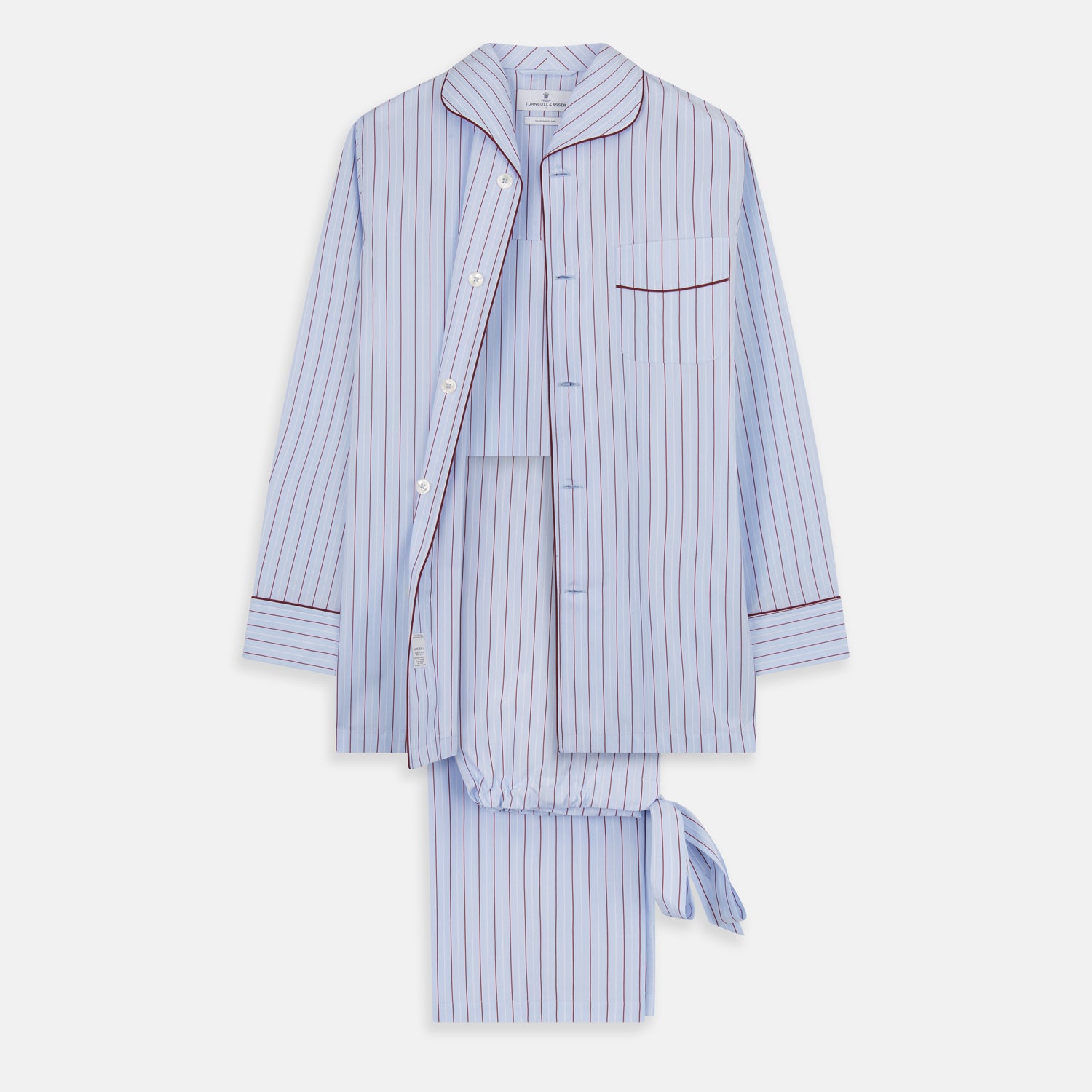 View 1 of product The Turnbull & Asser Burgundy Stripe Classic Pyjama Set features long sleeves, a button-up top with red piping, matching drawstring pants, and a traditional fit. Laid flat, it's luxury loungewear in signature burgundy stripes.