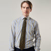 View 3 of product A man stands against a light background, wearing a Turnbull & Asser Yellow and Blue Fancy Check Regular Fit Shirt with T&A Collar, a patterned tie, dark dress pants, and black shoes. He faces forward with hands in pockets and a neutral expression.
